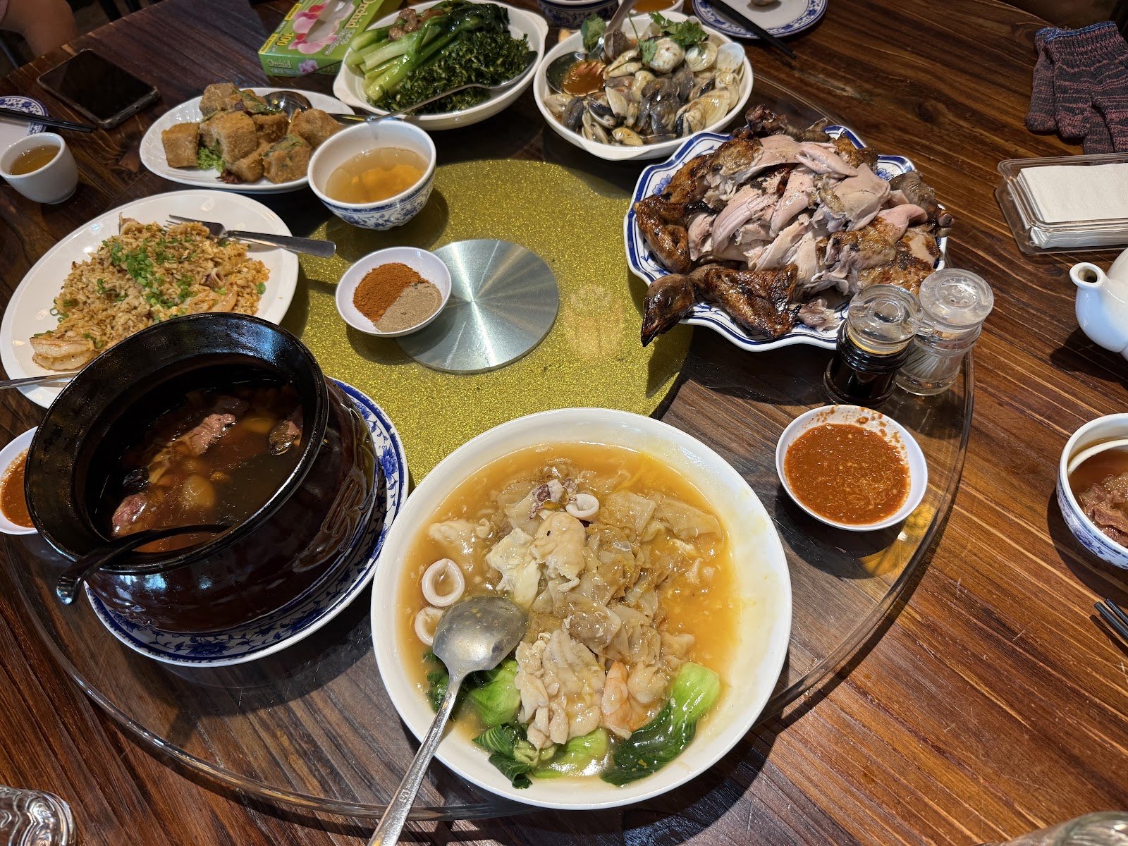 A round-table banquet at Half Acre with roasted meats, claypot, soup and stir-fried greens