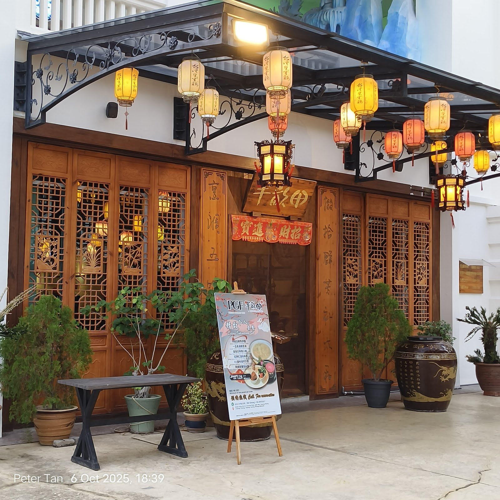 The lantern-framed entrance and wooden doors of Half Acre Restaurant at Straits Quay