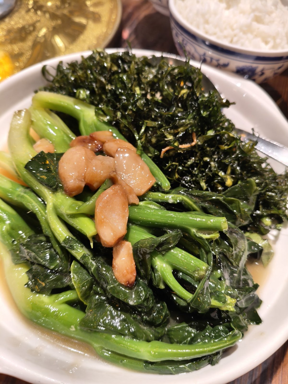 A plate of stir-fried greens topped with crispy garnish at Half Acre